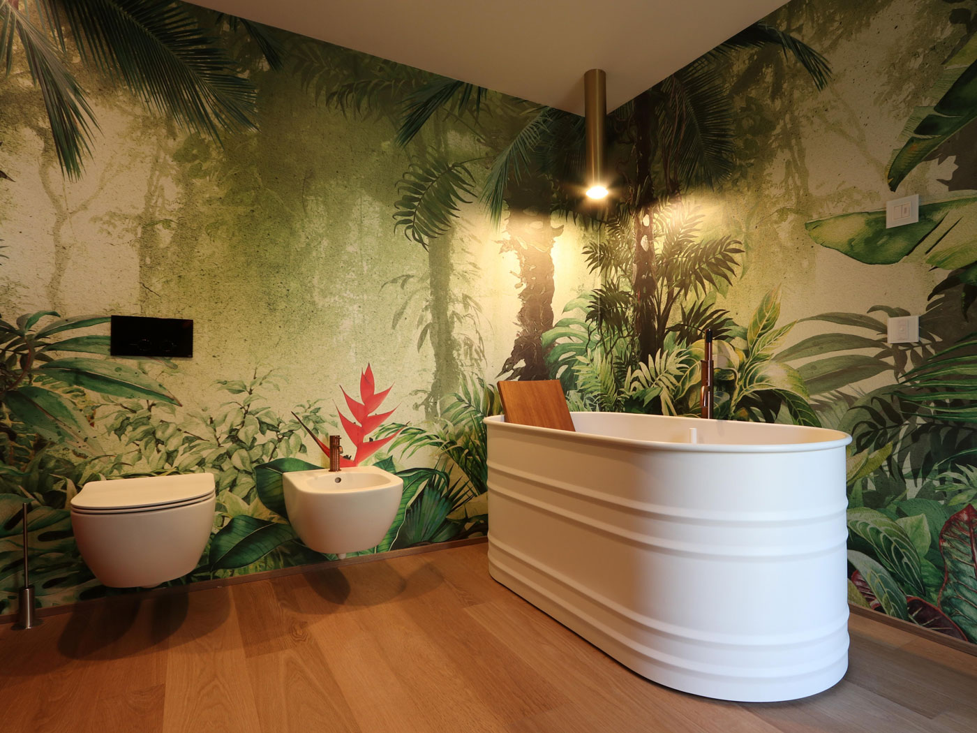 bagno con vasca free standing e carta da parati motivo vegetale